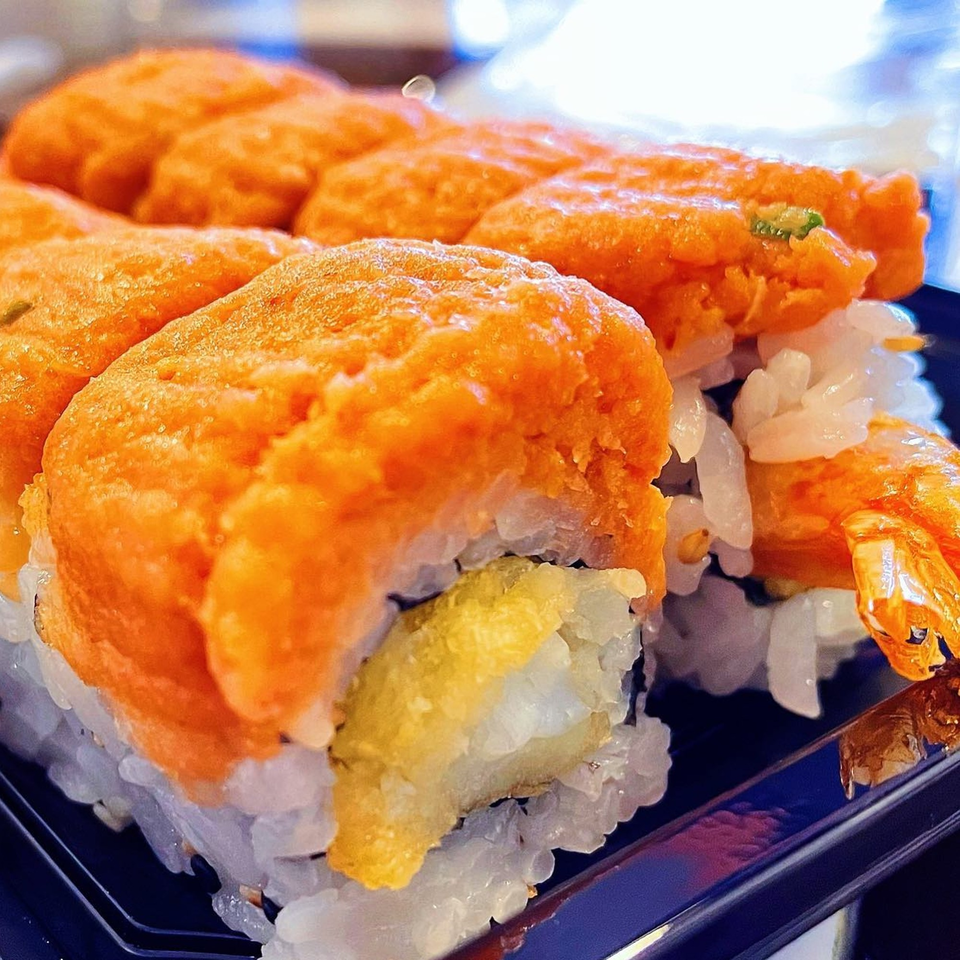 Close-up of Brick House Cafe's Japanese sushi rolls with bright orange topping and tempura shrimp.